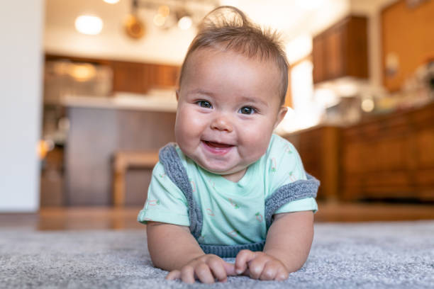 Cute baby laying on carpet floor | Basin Appliance Center